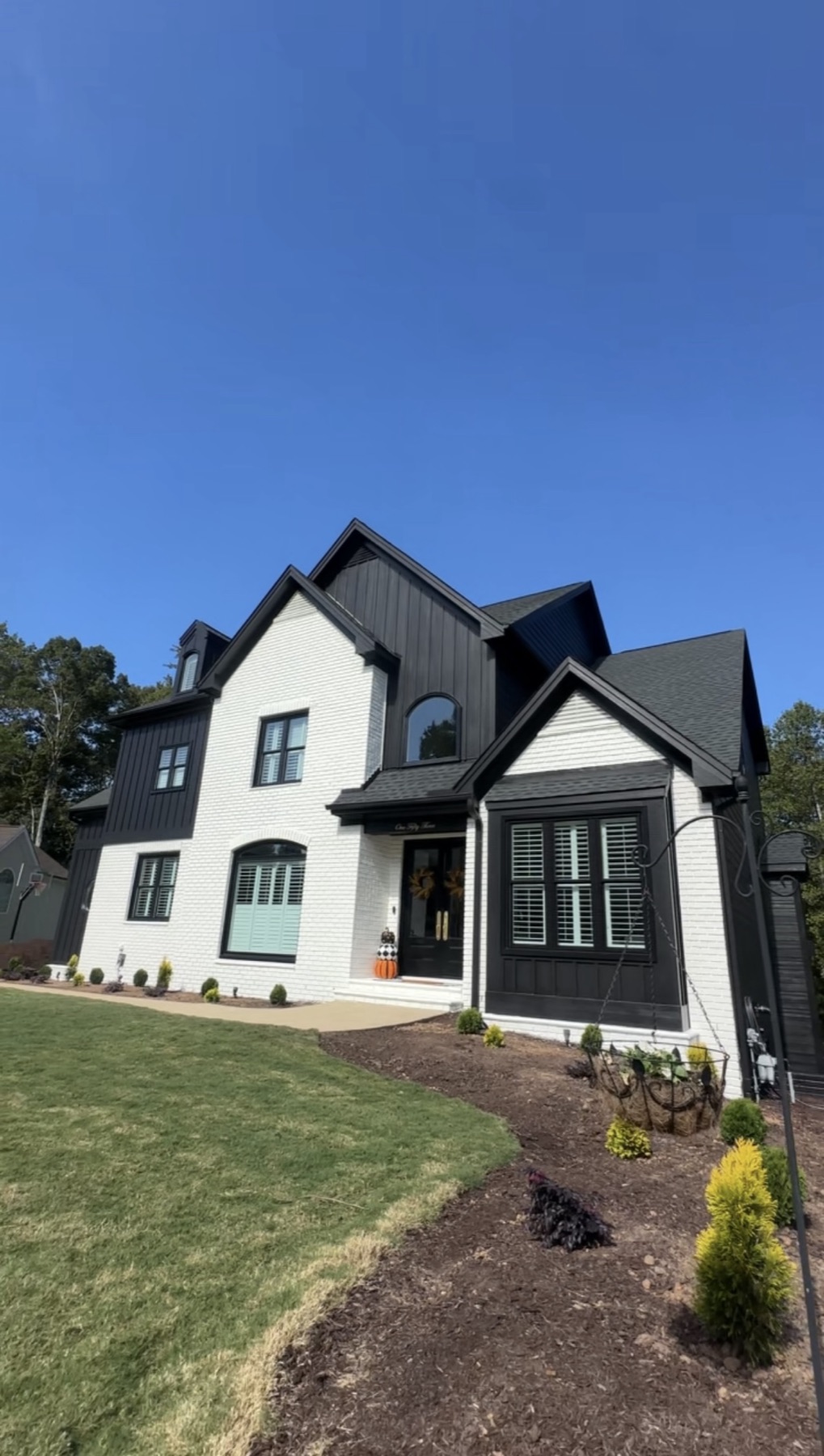 A modern white-and-black farmhouse freshly repainted by Mario's Painting NC